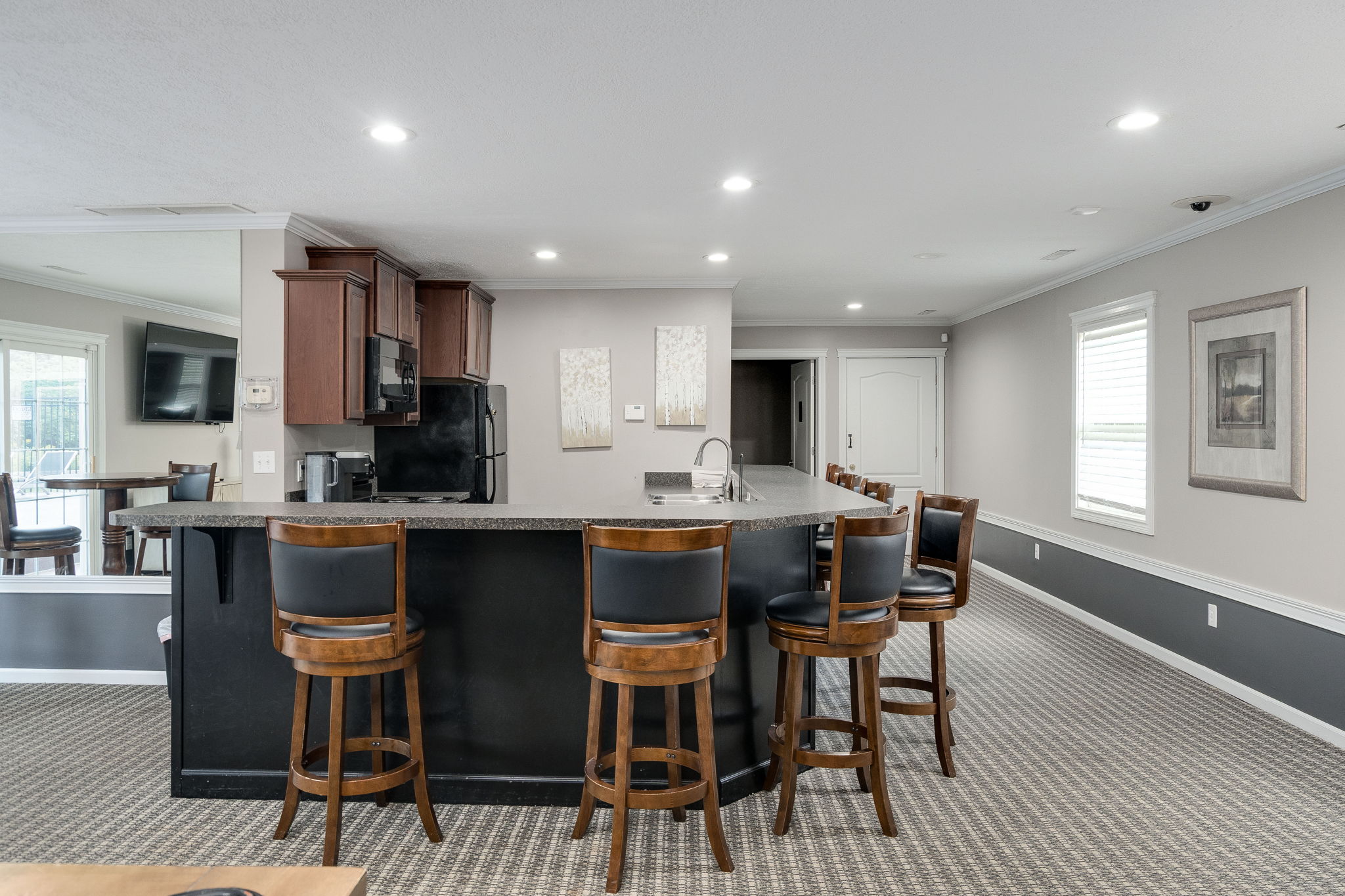 A modern kitchen with a bar area and seating.
